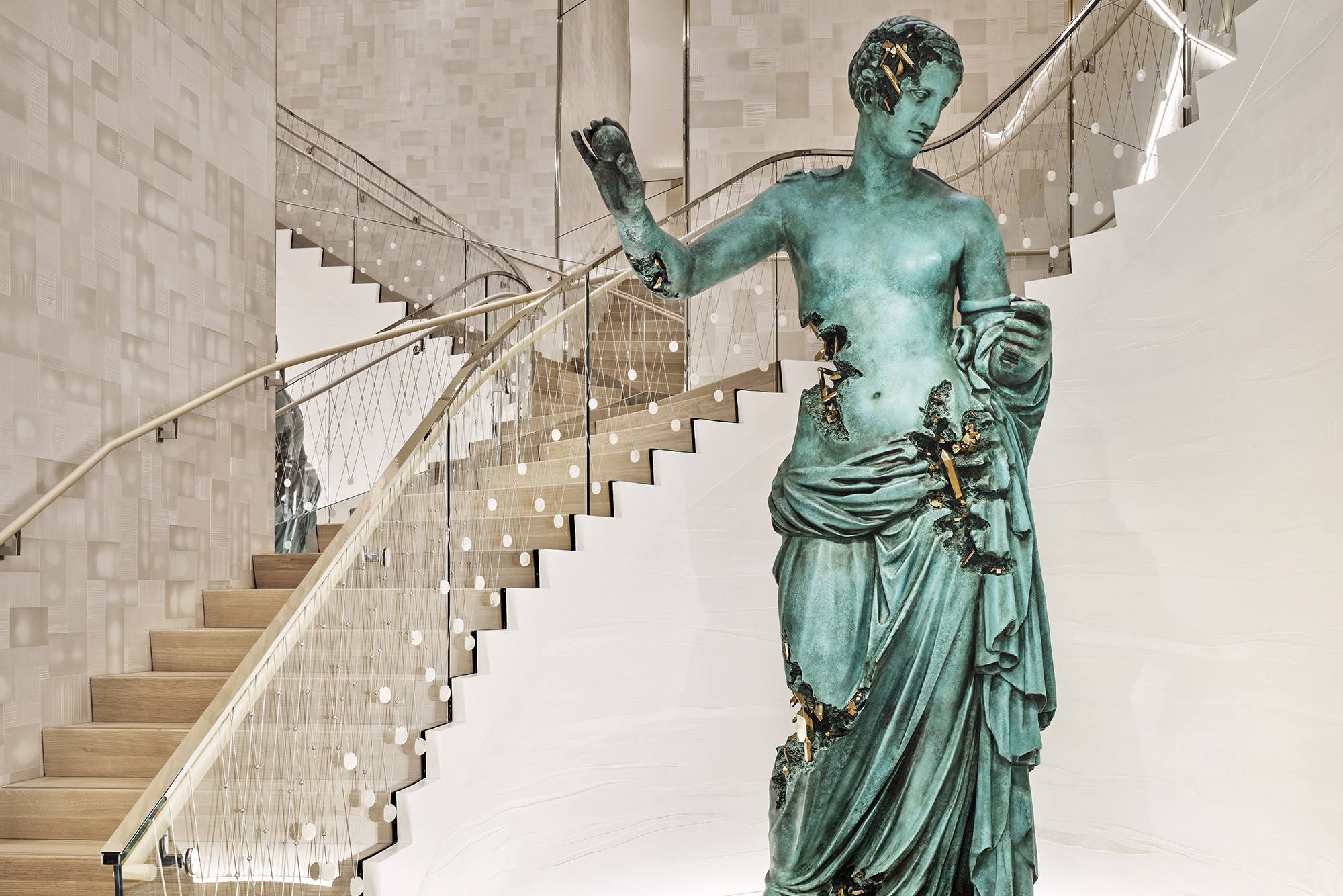 Tiffany & Co. The Landmark interior with teal statue and gold winding staircase